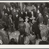 Auctioneer, buyers, and farmers during tobacco auction sale. Warehouse, Durham, North Carolina