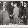The son of an older tobacco auctioneer relieves his father at the end of the row during sale. Mebane, Orange County, North Carolina