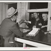 Farmers getting their checks in warehouse office after their tobacco has been sold at auction. Durham, North Carolina