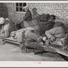 Farmers sleeping in [Black] camp room in warehouse. They often must remain overnight or several days before their tobacco is auctioned. Several of them are using an old tobacco basket for a pillow. Durham, North Carolina