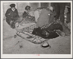 Farmers sleeping in [Black] camp room in warehouse. They often must remain overnight or several days before their tobacco is auctioned. One of them is using an old tobacco basket for a pillow. Durham, North Carolina