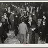 Auctioneer, buyers, and farmers during tobacco auction sale. Warehouse, Durham, North Carolina