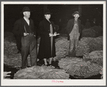 Farmer and his wife waiting for their tobacco to be sold at auction in warehouse. Durham, North Carolina