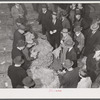 Tobacco auctioneer (in white gloves) and buyers during auction sale in warehouse in Mebane, Orange County, North Carolina