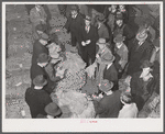 Tobacco auctioneer (in white gloves) and buyers during auction sale in warehouse in Mebane, Orange County, North Carolina