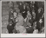 Tobacco auctioneer (in white gloves) and buyers during auction sale in warehouse in Mebane, Orange County, North Carolina