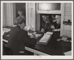 Farmers getting their checks in warehouse office after their tobacco has been sold at auction. Durham, North Carolina