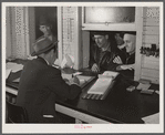 Farmers getting their checks in warehouse office after their tobacco has been sold at auction. Durham, North Carolina