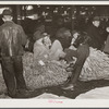 Farmers and friends waiting around in tobacco warehouse during auction sale. Durham, North Carolina