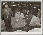 Farmers and friends waiting around in tobacco warehouse during auction sale. Durham, North Carolina