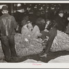 Farmers and friends waiting around in tobacco warehouse during auction sale. Durham, North Carolina