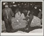 Farmers and friends waiting around in tobacco warehouse during auction sale. Durham, North Carolina