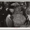 Auctioneer, buyers, and farmers during tobacco auction sale. Warehouse, Durham, North Carolina