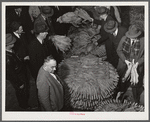 Auctioneer, buyers, and farmers during tobacco auction sale. Warehouse, Durham, North Carolina