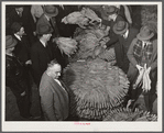 Auctioneer, buyers, and farmers during tobacco auction sale. Warehouse, Durham, North Carolina