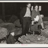 Farmer and his family waiting for their tobacco to be sold at auction in warehouse. Durham, North Carolina