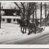 R.W. Cassidy, farmer in Putney, Vermont, hauling manure with his sled and team. He owns about two hundred acres, has lived here about seventeen years. Putney, Vermont