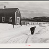 Farmer's son shoveling snow out of driveway near Putney, Vermont