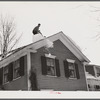 Shoveling heavy snow off roof of house in Woodstock, Vermont