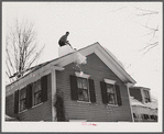 Shoveling heavy snow off roof of house in Woodstock, Vermont