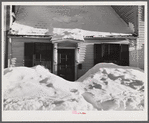 House in Woodstock, Vermont with drifts piled in front of windows and door