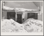 House in Woodstock, Vermont with drifts piled in front of windows and door
