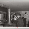 High school students getting warm and drying mittens by stove in ski hut