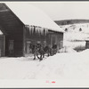 Clearing deep snow out of front barnyard so that if a sudden thaw comes, the cellar and first floor of house and barn will not be flooded. Putney farm, Woodstock, Vermont