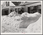 Snow slides off the roof and piles high in front of window of farmhouses. Woodstock, Vermont
