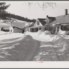 Snow slides off the roof and piles high in front of window of farmhouses. Woodstock, Vermont