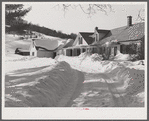 Snow slides off the roof and piles high in front of window of farmhouses. Woodstock, Vermont
