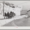 Clinton Gilbert, farmer, and his helper hauling water in milk cans on sled, as their sources of water supply were frozen for two months during very severe winter. Woodstock, Vermont