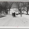 Clinton Gilbert, farmer, and his helper hauling water in milk cans on sled, as their sources of water supply were frozen for two months during very severe winter. Woodstock, Vermont