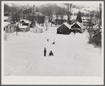 Children sleigh riding down hill in center of town. Woodstock, Vermont