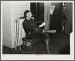 Railroad worker waiting in baggage room for train arrival. Railway station, Mount Whittier, New Hampshire