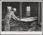 Sawing board in woodworking shop. Community service center, Centerville, Arkansas. Faulkner County (see general caption)