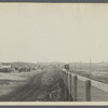 View of Montauk. Long Island Sound side. Railroad tracks, train, station in center. Montauk Inn on right. Montauk, East Hampton