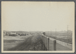 View of Montauk. Long Island Sound side. Railroad tracks, train, station in center. Montauk Inn on right. Montauk, East Hampton