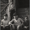 Four young boys on the stairs of a building stoop