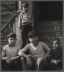 Four young boys on the stairs of a building stoop