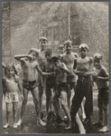 Group of children posing on the street, wet from the fire hydrant spraying