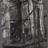 Woman and young child watching the street from the window and fire escape 