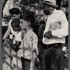 Adults and children standing in a park