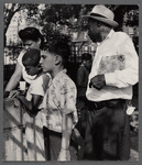 Adults and children standing in a park