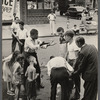 Street scene, group of men engaging in conversation with onlookers