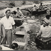 People in row boats, crowding the edge of a waterway