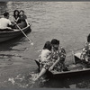 People in row boats, woman seated with feet in the water