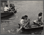 People in row boats, woman seated with feet in the water