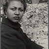 Portrait of a woman with sparkling earring, brick rubble and buildings in the background