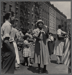 Crowded street scene with woman playing tambourine 